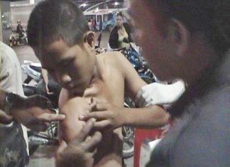 One of the victims shows his gunshot wound to paramedics.